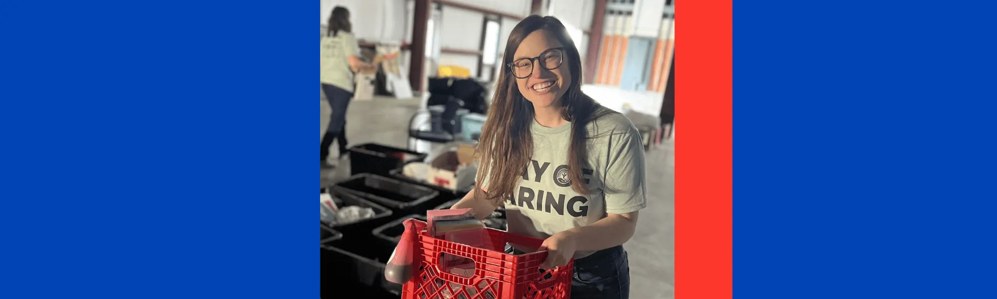 Volunteer carries a bin while organizing materials at local nonprofit